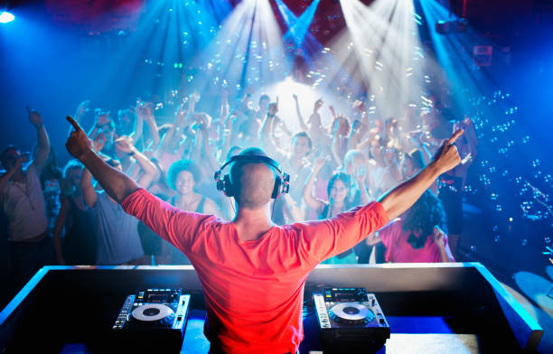 DJ with arms outstretched overlooking dance floor  dj stock pictures, royalty-free photos & images