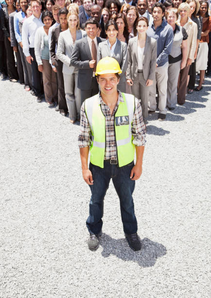 portrait of smiling construction worker with business people in background - teamwork business construction confidence 뉴스 사진 이미지