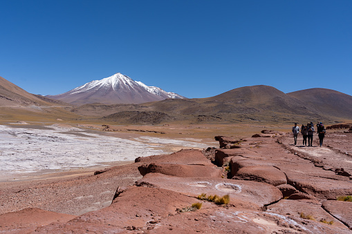 San Pedro de Atacama, Chile - February 23, 2023: Tourists visiting Red Rocks (Piedras Rojas), lagoon and salt flats  in Atacama Desert, Chile.