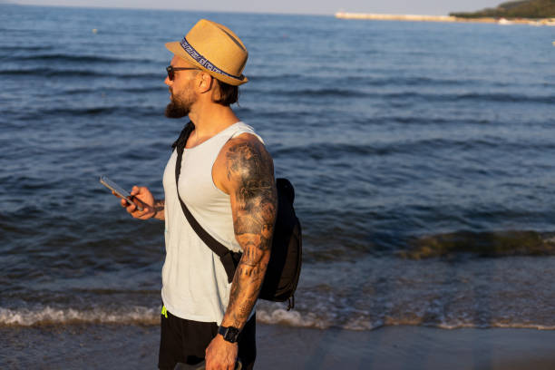 istock Man walking at the beach and carrying a backpack 1609959908