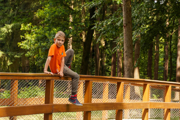 istock Cute guy resting on a bridge in the park. 1609967364