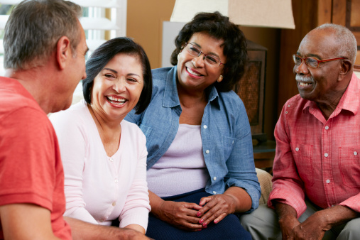 Group Of Senior Friends Chatting At Home Together Smiling