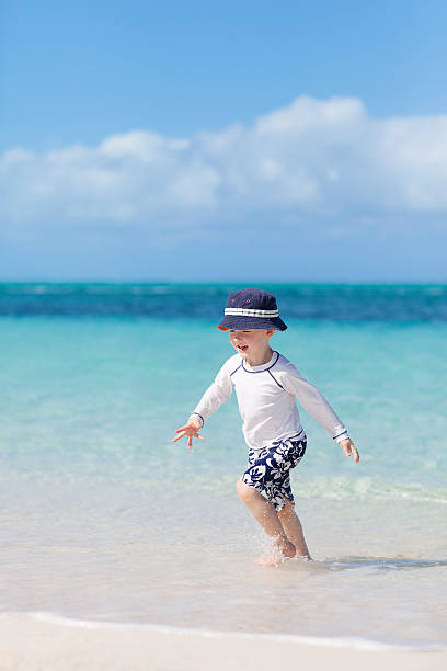 kleine junge am tropischen strand - providenciales stock-fotos und bilder