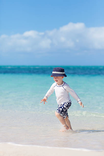 petit garçon à la plage tropicale - providenciales photos et images de collection