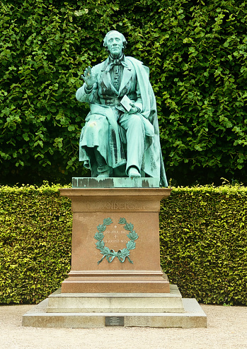 Copenhagen King's Garden (Kongens Have) public park:frontal view of  bronze monument to Hans Christian Andersen with a book in hand, by August V. Saabye in 1880
