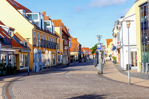 Skagen city street with traditional yellow houses and restaurants, cafes and boutiques on a summer sunny day. Skagen, Denmark - August 12, 2023.