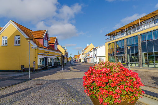 Skagen city street with traditional yellow houses and restaurants, cafes and boutiques on a summer sunny day. Skagen, Denmark - August 12, 2023.