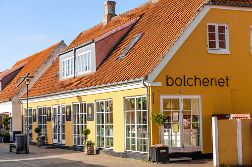 Skagen city street with traditional yellow houses and restaurants, cafes and boutiques on a summer sunny day. Skagen, Denmark - August 12, 2023.