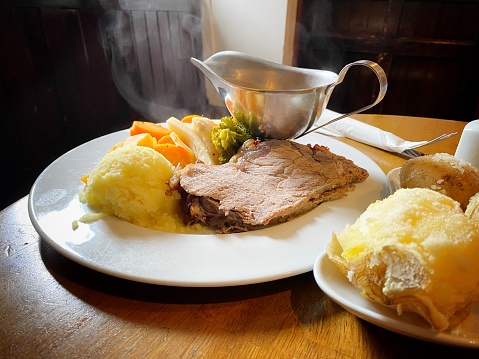 Steaming hot roast beef with mashed potatoes and vegetables carvery pub lunch