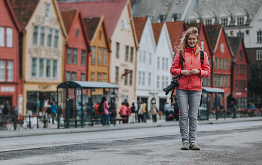 Woman tourist with camera on Bryggen Hanseatic Wharf, Bergen, Norway