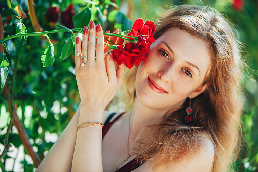 Young blond woman with red rose portrait