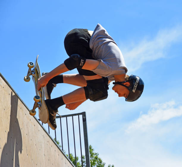 St Neots, Cambridgeshire, England - July 03, 2022: Skateboarder performing stunt on Vert Ramp.