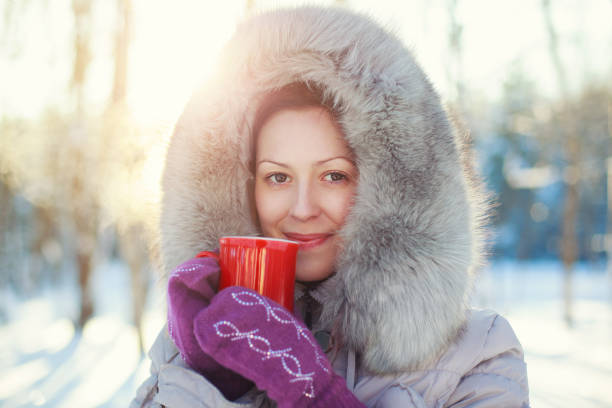 Young woman with warm mug winter portrait at sunset light