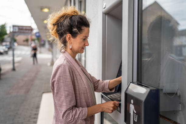 istock woman using credit card and withdrawing cash at the ATM 1610275921