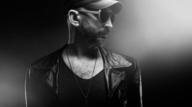 istock Stylish handsome man wearing leather jacket with heart shaped sunglasses 1610281177