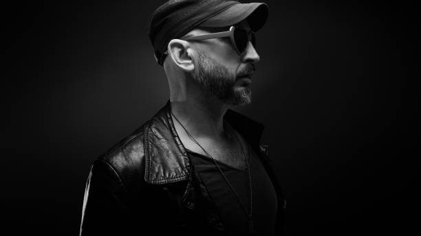 istock Stylish handsome man wearing leather jacket with heart shaped sunglasses 1610281191