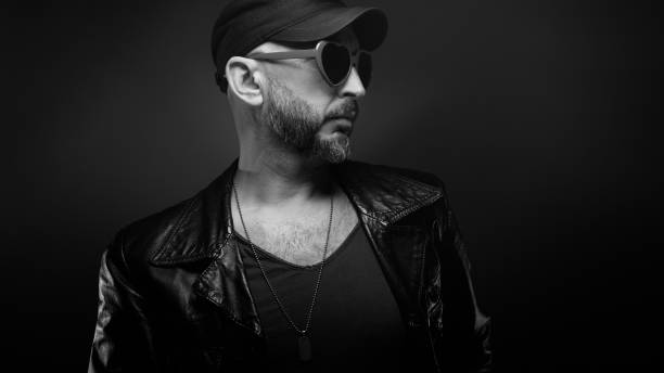 istock Stylish handsome man wearing leather jacket with heart shaped sunglasses 1610281721