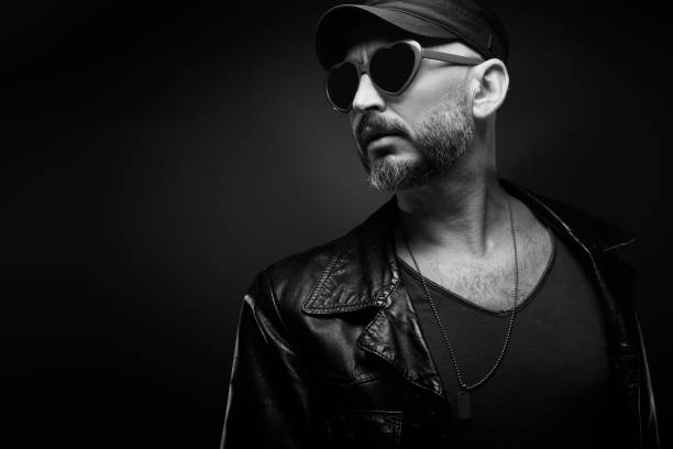 istock Stylish handsome man wearing leather jacket with heart shaped sunglasses 1610286493