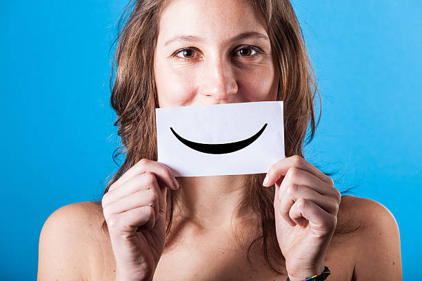 istock Young Woman with Smiley Emoticon on Blue Background 161029703