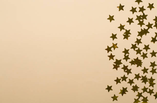 istock Golden confetti stars on color background, top view 1610322451