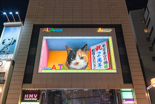 tokyo, japan - aug 7 2023: Closeup on the facade of Alta building with a large advertising screen promoting the second anniversary of the super realistic giant 3D cat at Shinjuku Stations east exit.