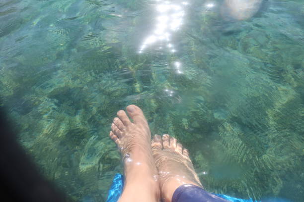 エジプトのシナイ半島のラス・シタンの青いターコイズブルーの水の下の女性の足 - red sea taba sand reef ストックフォトと�画像