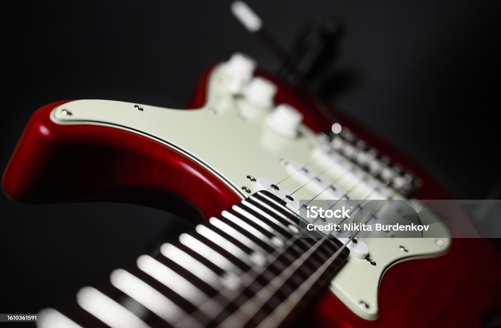 Close-up of a red electric guitar on a black background. Selective narrow focus on pickup. Electric Guitar Stock Photo