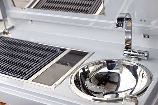 Sink and gas stove on luxury motorboat, background with copy space, full frame horizontal composition