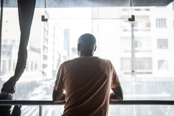 istock Contemplative mature man looking through the window 1610375514