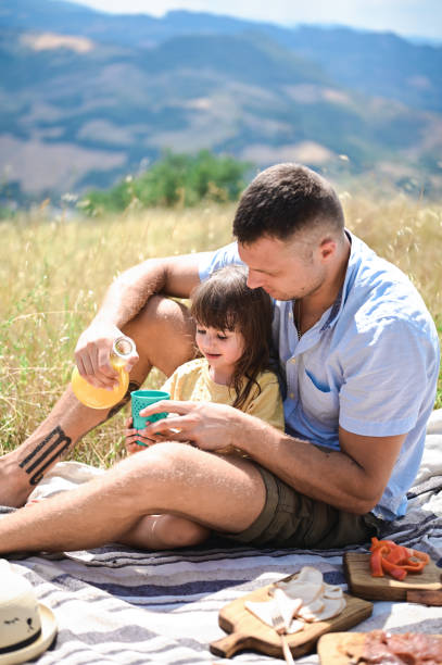 istock Young father and daughter having a picnic in nature. 1610410883