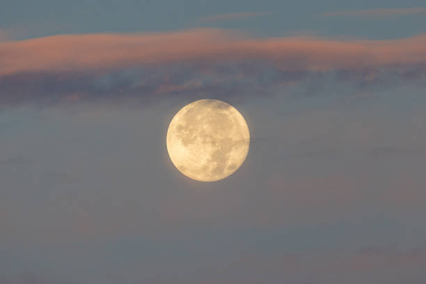 istock Full moon at dawn surrounded by colorful clouds 1610425749
