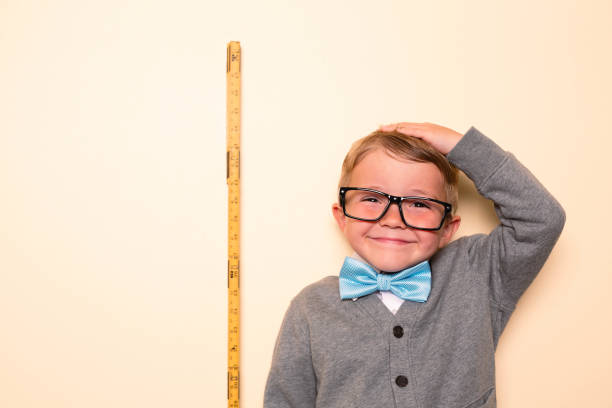 joven nerd midiendo la altura - little boys measuring expressing positivity intelligence fotografías e imágenes de stock