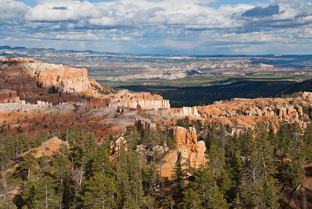 Forested Canyon and Rock Formation Bryce Canyon is famous for its tall thin spires of rock known as hoodoos. Hoodoos start with an initial deposition of rock. Then over time the rock is uplifted then eroded and weathered. Hoodoos typically consist of relatively soft rock topped by harder, less easily eroded stone that protects each column from the weather. Hoodoos generally form within sedimentary rock such as sandstone. These hoodoos were photographed from Sunrise Point in Bryce Canyon National Park, Utah, USA. jeff goulden bryce canyon national park stock pictures, royalty-free photos & images