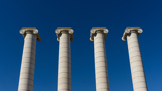 Barcelona, Spain. 03.26.2023. The Four Columns in Barcelona, in front of the National Art Museum of Catalonia. Blue sky and isolated columns.