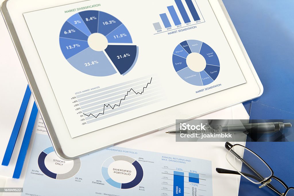 Financial analysis comparison with digital tablet Modern workflow and financial analysis with digital tablet, selective focus on the pen. Banking Document Stock Photo