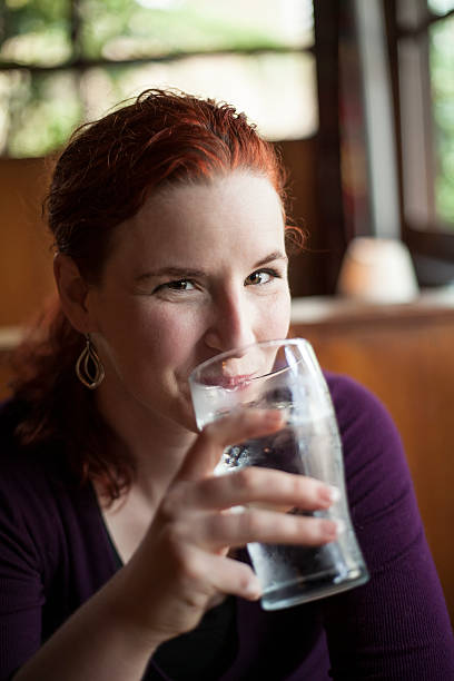 istock Young Woman with Beautiful Auburn Hair Drinking Water 161059430