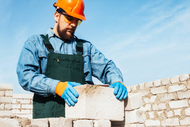 istock Male construction worker in uniform building wall. 1610631378