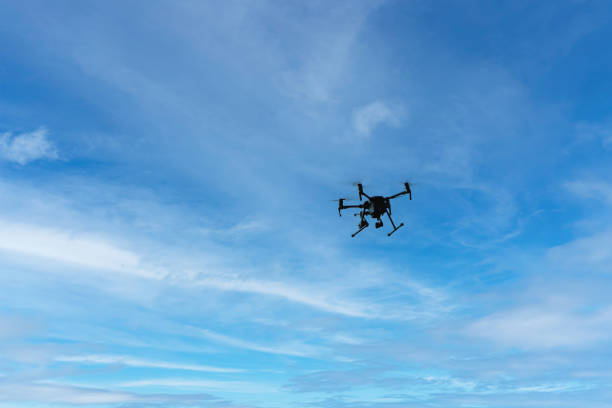 istock Drone on a background of blue sky with clouds. quadcopter in flight. sunny day. 1610673521