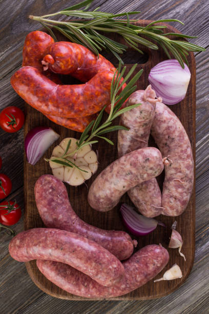 Cutting board with many raw sausages stock photo