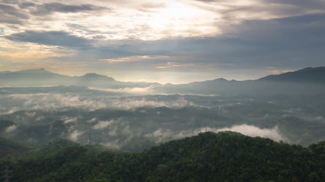 4K motion time lapse video aerial view morning scenery Mist flowing over the high mountains The movement of fog and clouds, Baan Pang Puai, Mae Moh, Lampang, Thailand