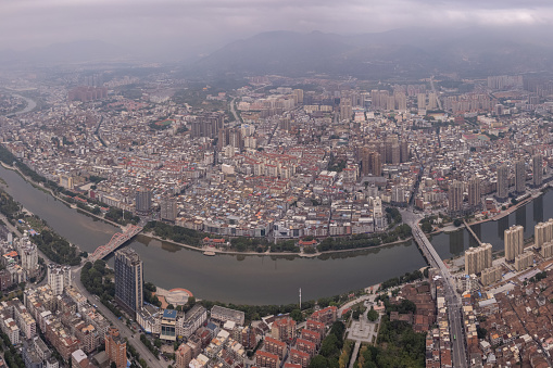 Aerial view of densely populated buildings in city with river on cloudy day