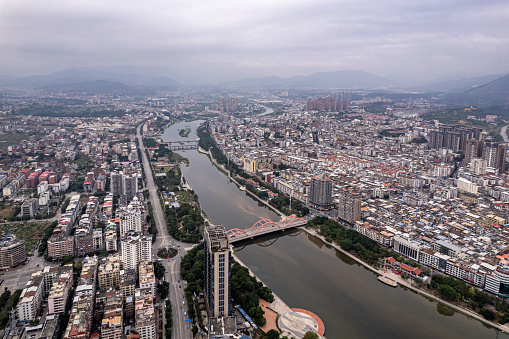 Aerial view of densely populated buildings in city with river on cloudy day