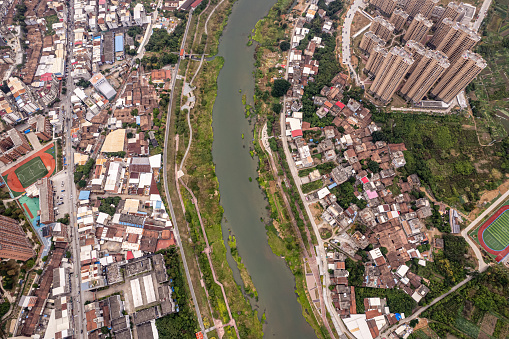 Vertical bird's-eye view of densely populated urban residential buildings along the river
