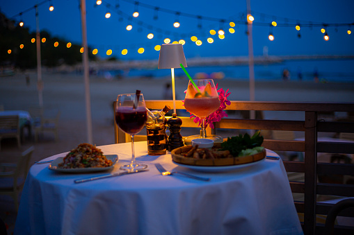 seaside dinner table,Romantic dinner setting on the beach at sunset