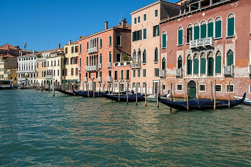 Venice, Italy – September 19, 2022: A vibrant cityscape, featuring a river lined with high-rise buildings and small boats