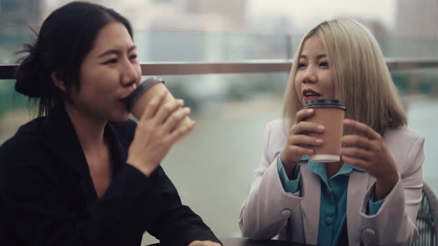 Business strategy discussion between two Asian women on high-rise building