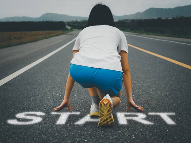 istock Woman preparing to run start text on asphalt road 1610963354