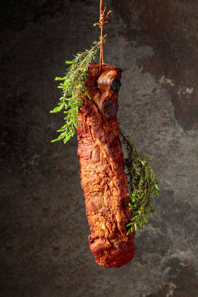 istock Smoked pork ribs with juniper branches on an old stone background. 1611061892
