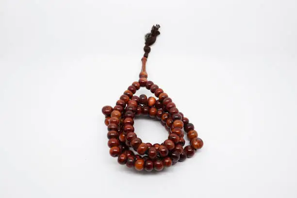 Photo of Brown prayer beads on white background. Photo stock