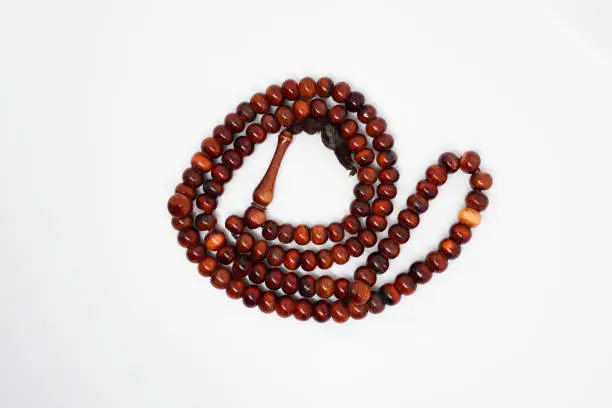Photo of Brown prayer beads on white background. Photo stock
